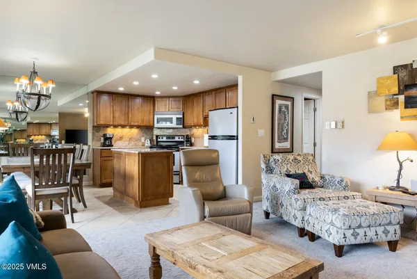 a living room with furniture and a dining table with kitchen view