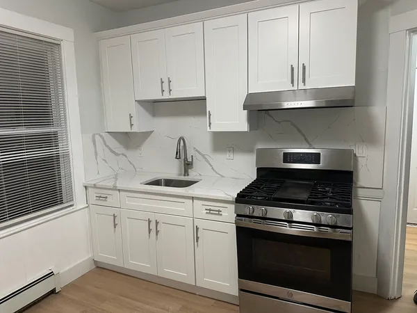 a kitchen with white cabinets and appliances