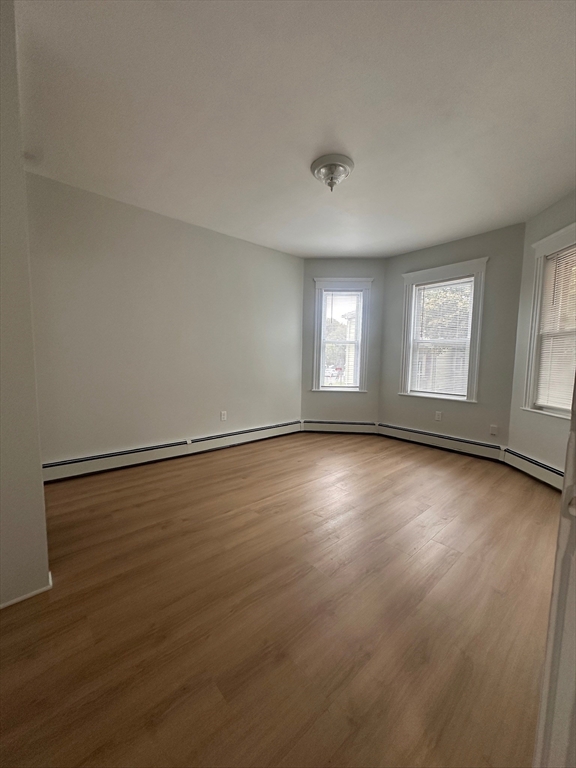 5 Crowell Street, Unit 1 Boston, MA 02124 - Photo 4 of 8 an empty room with wooden floor and windows