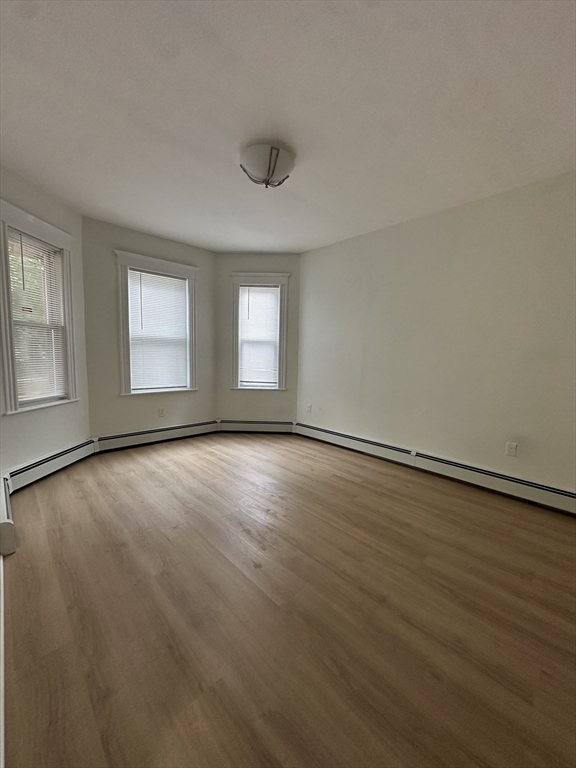 5 Crowell Street, Unit 1 Boston, MA 02124 - Photo 8 of 8 an empty room with wooden floor and windows
