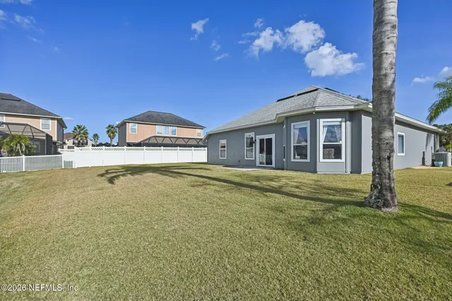 a front view of a house with a yard and trees