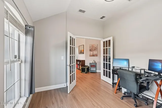 a view of a workspace with wooden floor and a window
