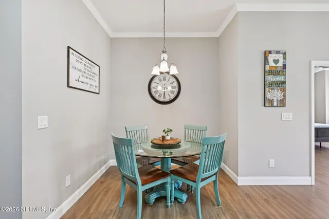 a kitchen with stainless steel appliances granite countertop a refrigerator a sink dishwasher a stove and white countertops with wooden floor