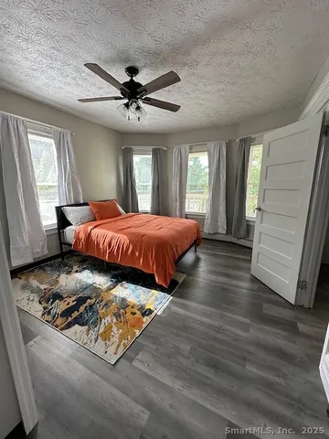 a bedroom with a bed window and wooden floor