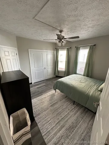 a bedroom with a bed mirror and furniture