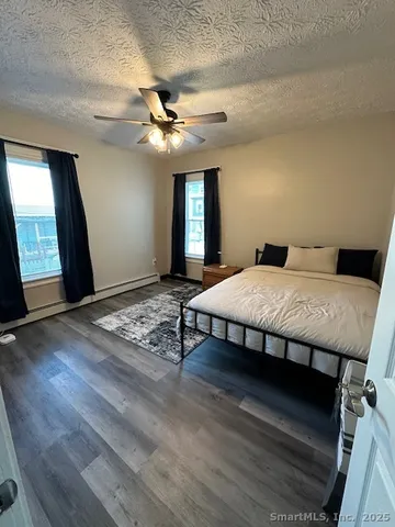 a bedroom with a bed mirror on desk and a window