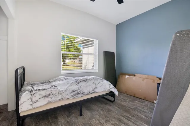 a bedroom with a bed and wooden floor