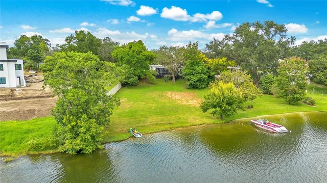 an aerial view of residential houses with outdoor space and lake view