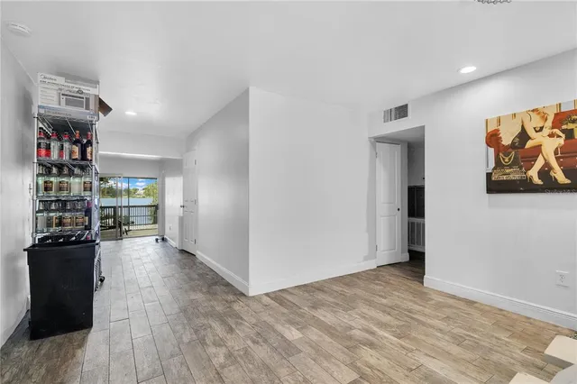 a view of a hallway with wooden floor and windows