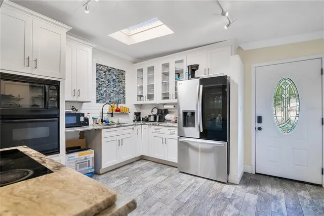 a kitchen with a refrigerator and white cabinets