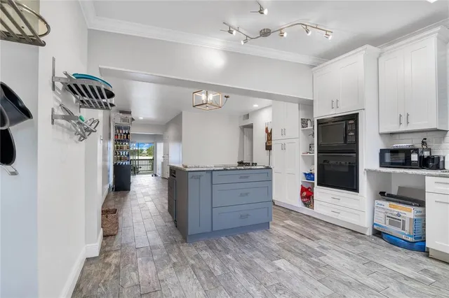 a open kitchen with cabinets a stove and a wooden floor