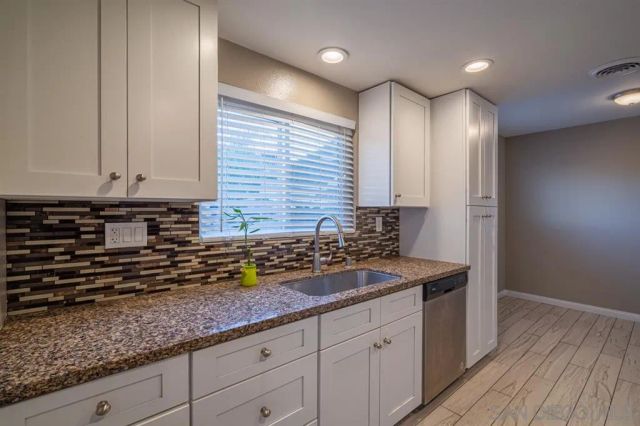 a kitchen with granite countertop stainless steel appliances a sink and cabinets