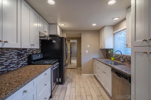 a kitchen with stainless steel appliances granite countertop a sink stove and refrigerator
