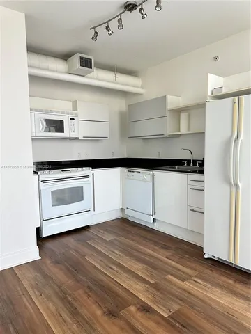 a kitchen with cabinets and wooden floor