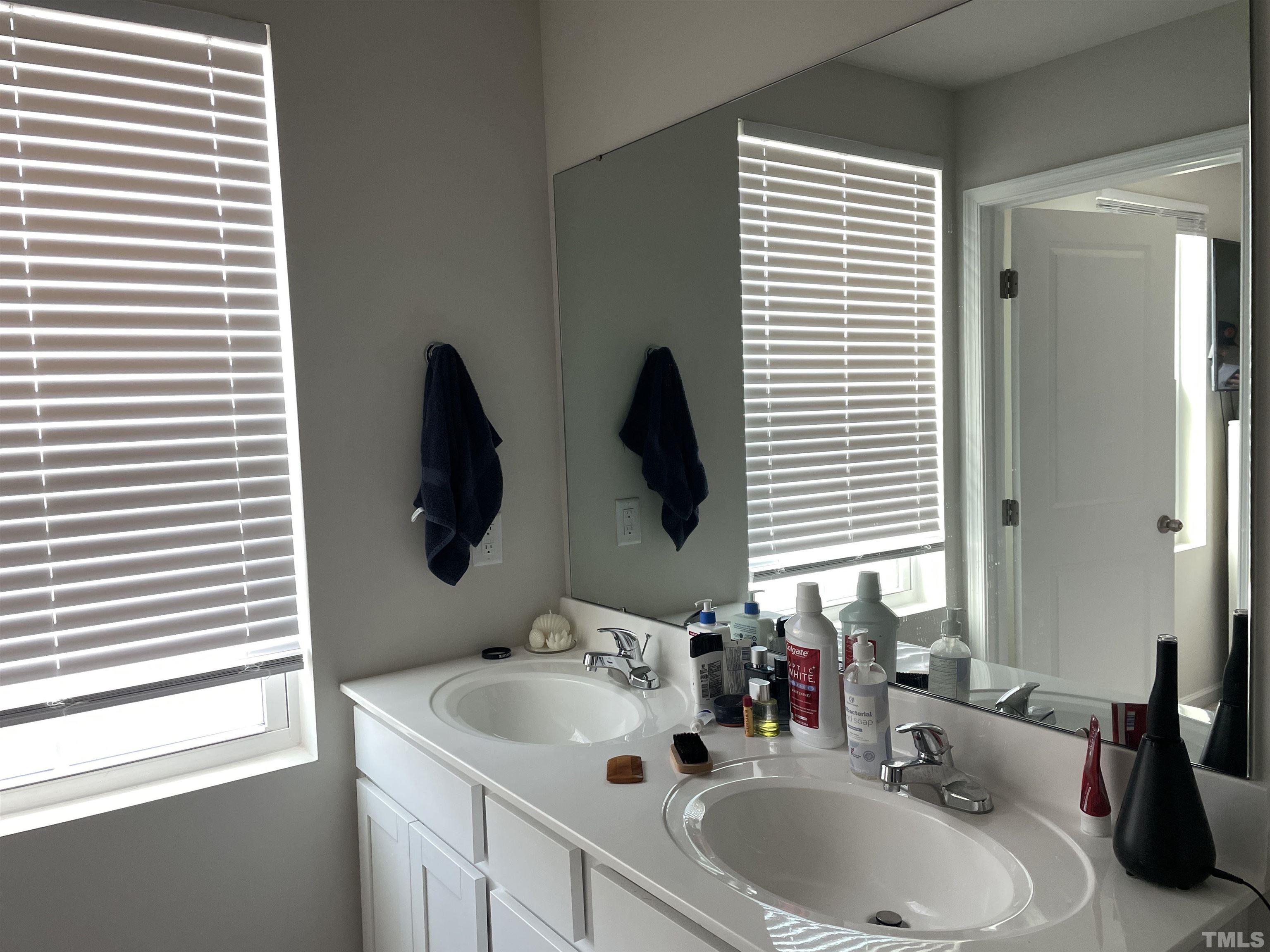 1016 Bent Willow Drive Durham, NC 27704 - Photo 12 of 20 a bathroom with a double vanity sink and mirror with window