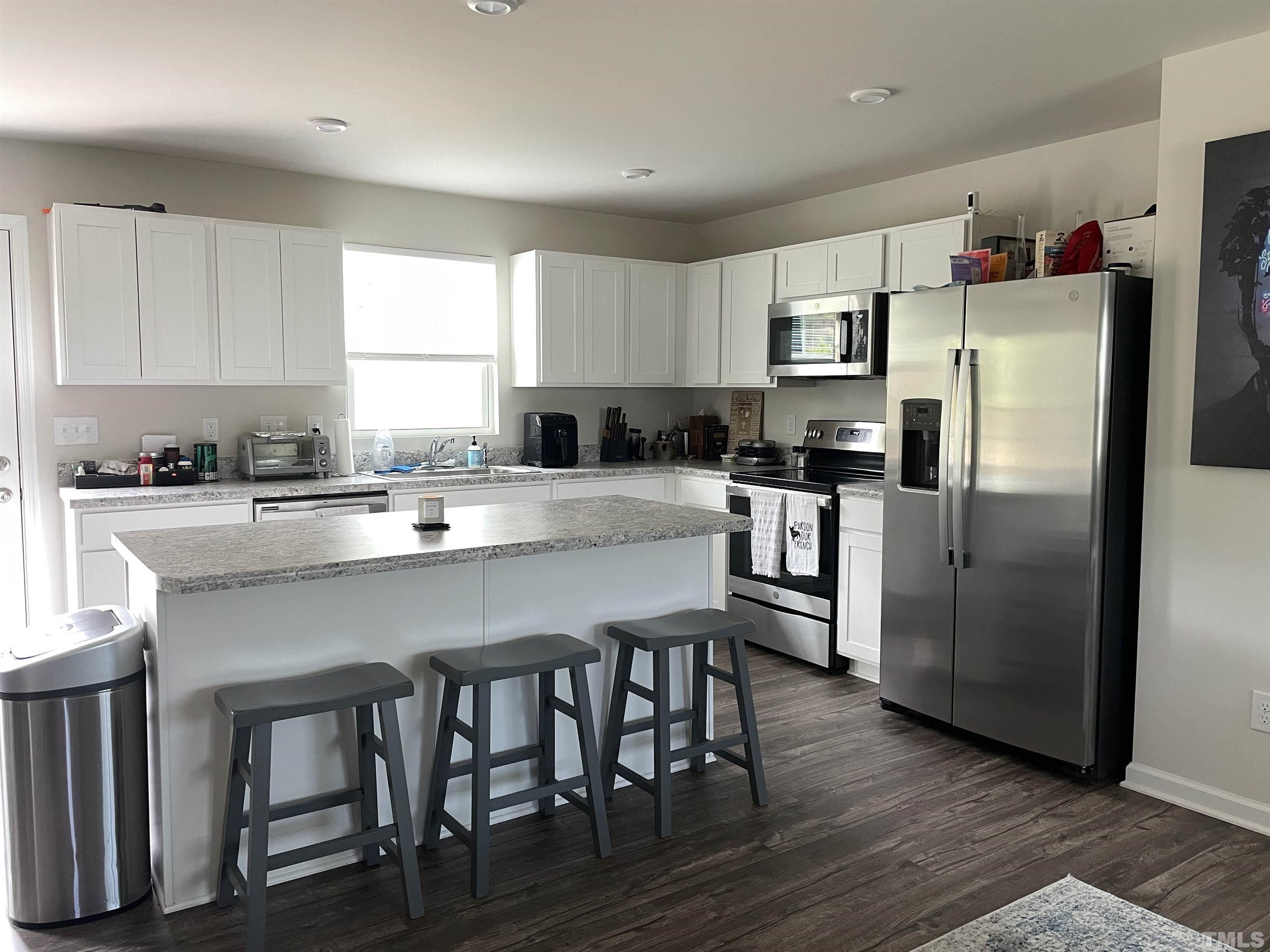 1016 Bent Willow Drive Durham, NC 27704 - Photo 6 of 20 a kitchen with granite countertop a center island stainless steel appliances cabinets and a window
