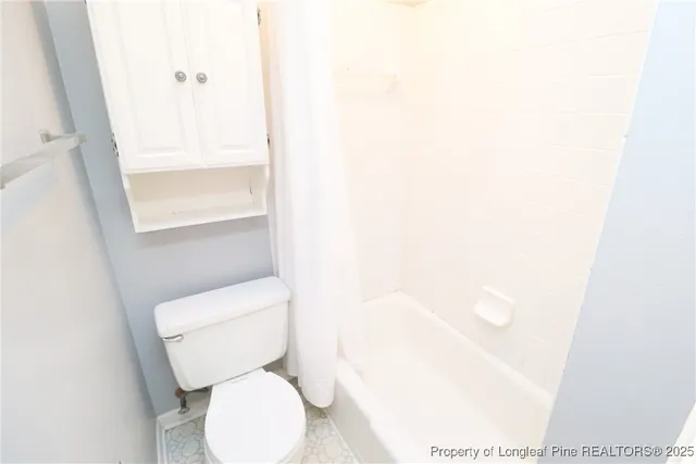 a white toilet sitting next to a shower