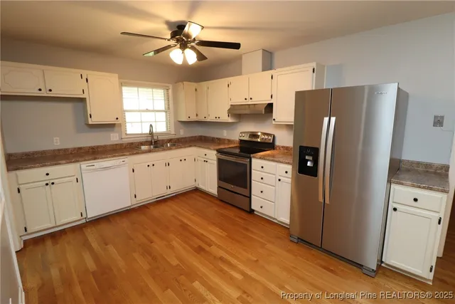 a kitchen with white cabinets and white appliances