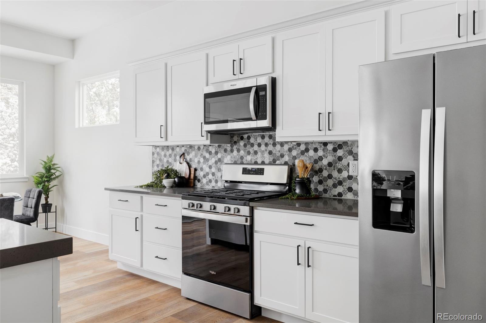597 Rider Ridge Drive Longmont, CO 80504 - Photo 9 of 31 a kitchen with stainless steel appliances a stove a microwave and a refrigerator
