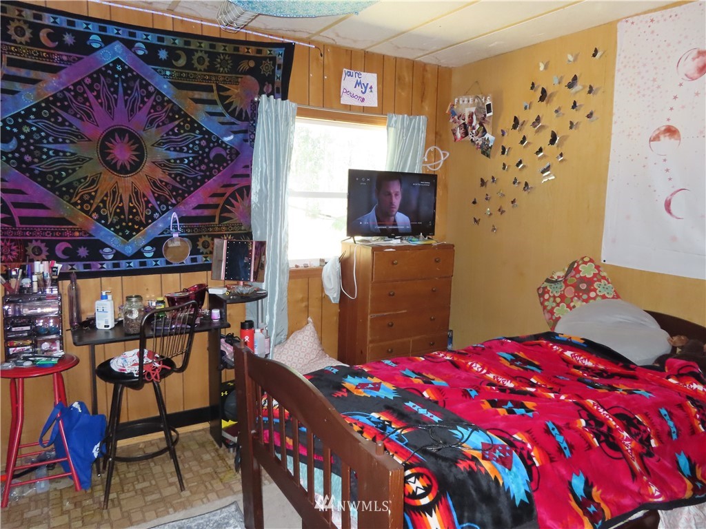 347 West Curlew Lake Road Republic, WA 99166 - Photo 15 of 26 a bedroom with a bed a dresser and a painting on the wall