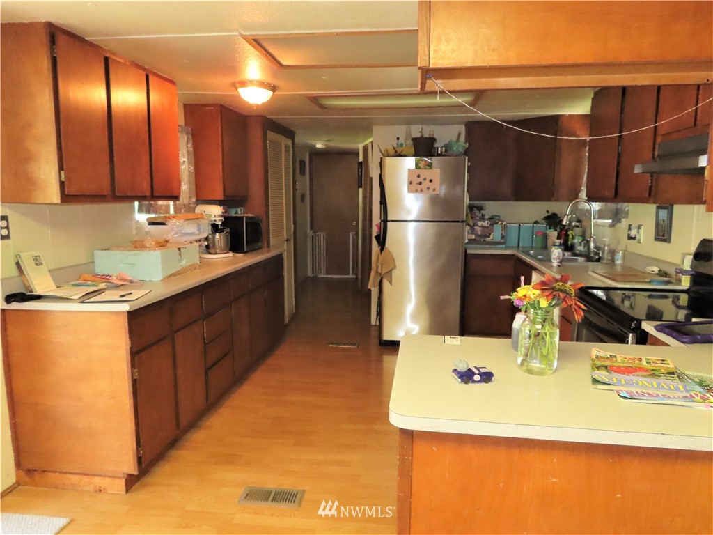 347 West Curlew Lake Road Republic, WA 99166 - Photo 4 of 26 a kitchen with stainless steel appliances kitchen island granite countertop a sink refrigerator and cabinets