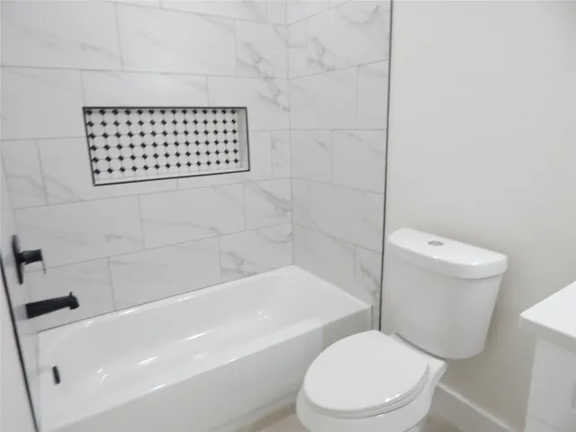 a white toilet sitting next to a bath tub