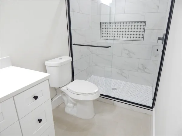 a bathroom with a toilet and a shower
