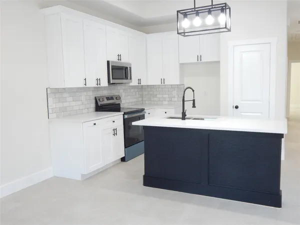 a kitchen with stainless steel appliances granite countertop a sink stove and microwave