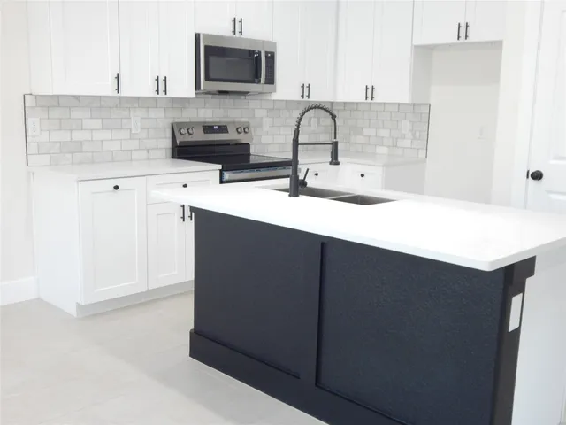 a kitchen with stainless steel appliances a sink and a microwave