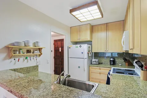 a kitchen with a refrigerator sink and cabinets