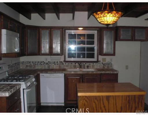 151 Cedar Lane Road Crestline, CA 92325 - Photo 3 of 8 a kitchen with a sink and a stove