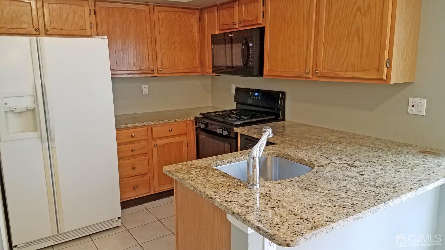 311 Classon Court Somerset, NJ 08873 - Photo 11 of 20 a kitchen with stainless steel appliances granite countertop a sink stove and refrigerator