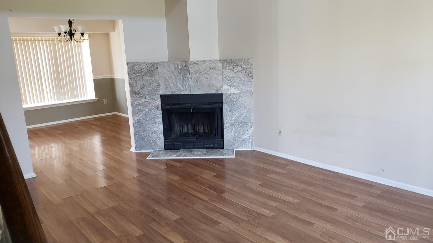 311 Classon Court Somerset, NJ 08873 - Photo 7 of 20 an empty room with wooden floor fireplace and windows