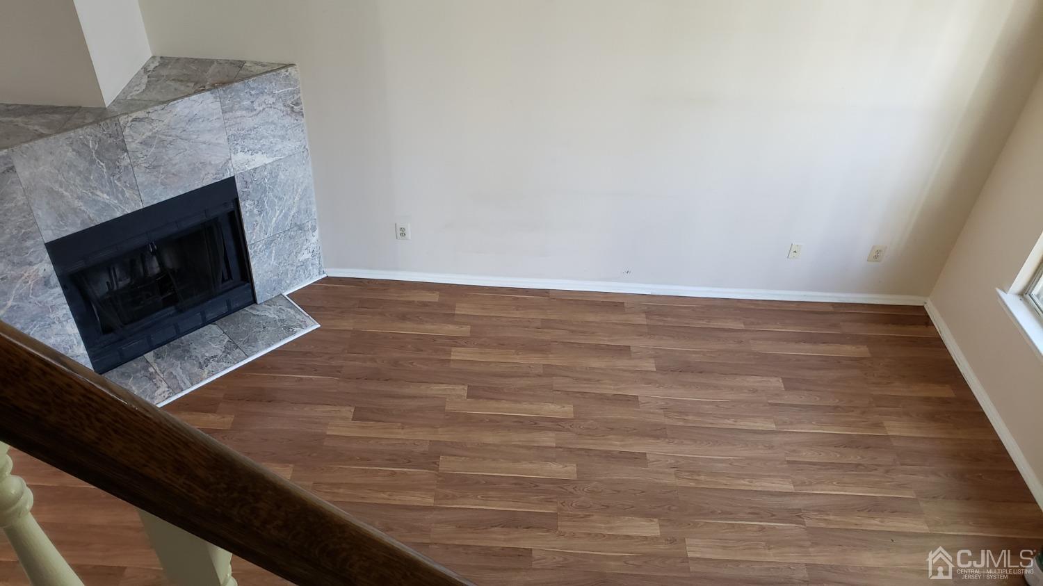 311 Classon Court Somerset, NJ 08873 - Photo 8 of 20 a view of an empty room with wooden floor and a fireplace