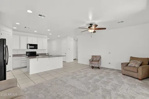 a living room with stainless steel appliances kitchen island furniture and a television