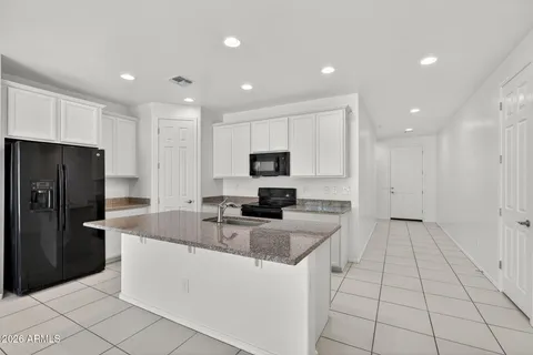 a large kitchen with stainless steel appliances lots of counter top and refrigerator