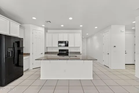 a kitchen with stainless steel appliances granite countertop a sink a refrigerator and a granite counter tops