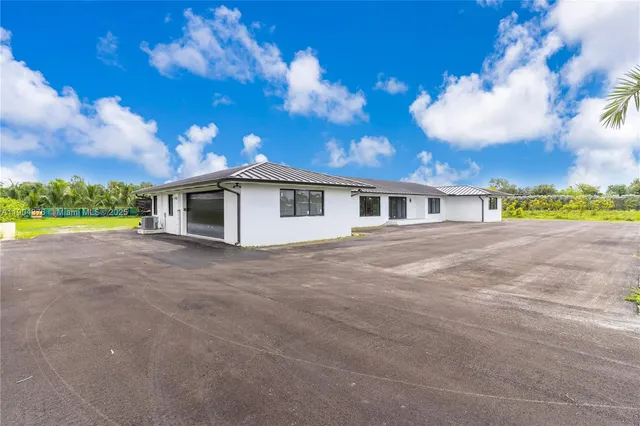 a front view of a house with a garden and yard