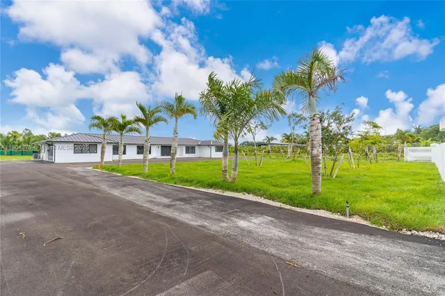 a view of a big yard with palm trees