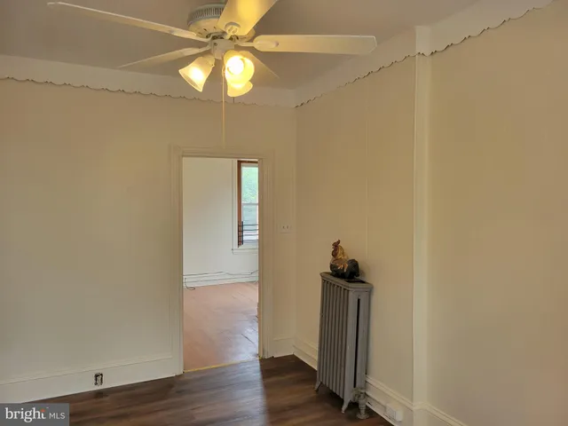 a view of a hallway with wooden floor and chandelier