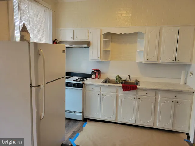 a kitchen with stainless steel appliances white cabinets and a refrigerator
