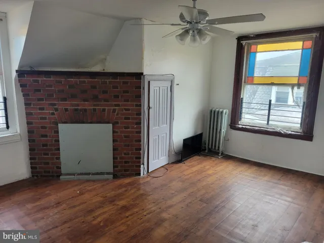 an empty room with windows and fireplace