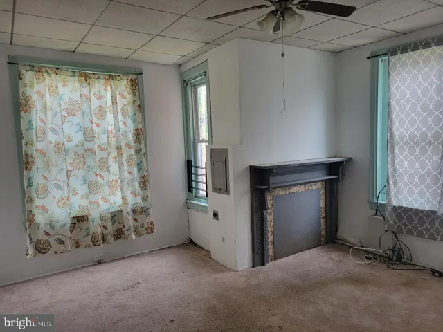 a view of empty room with window and ceiling fan