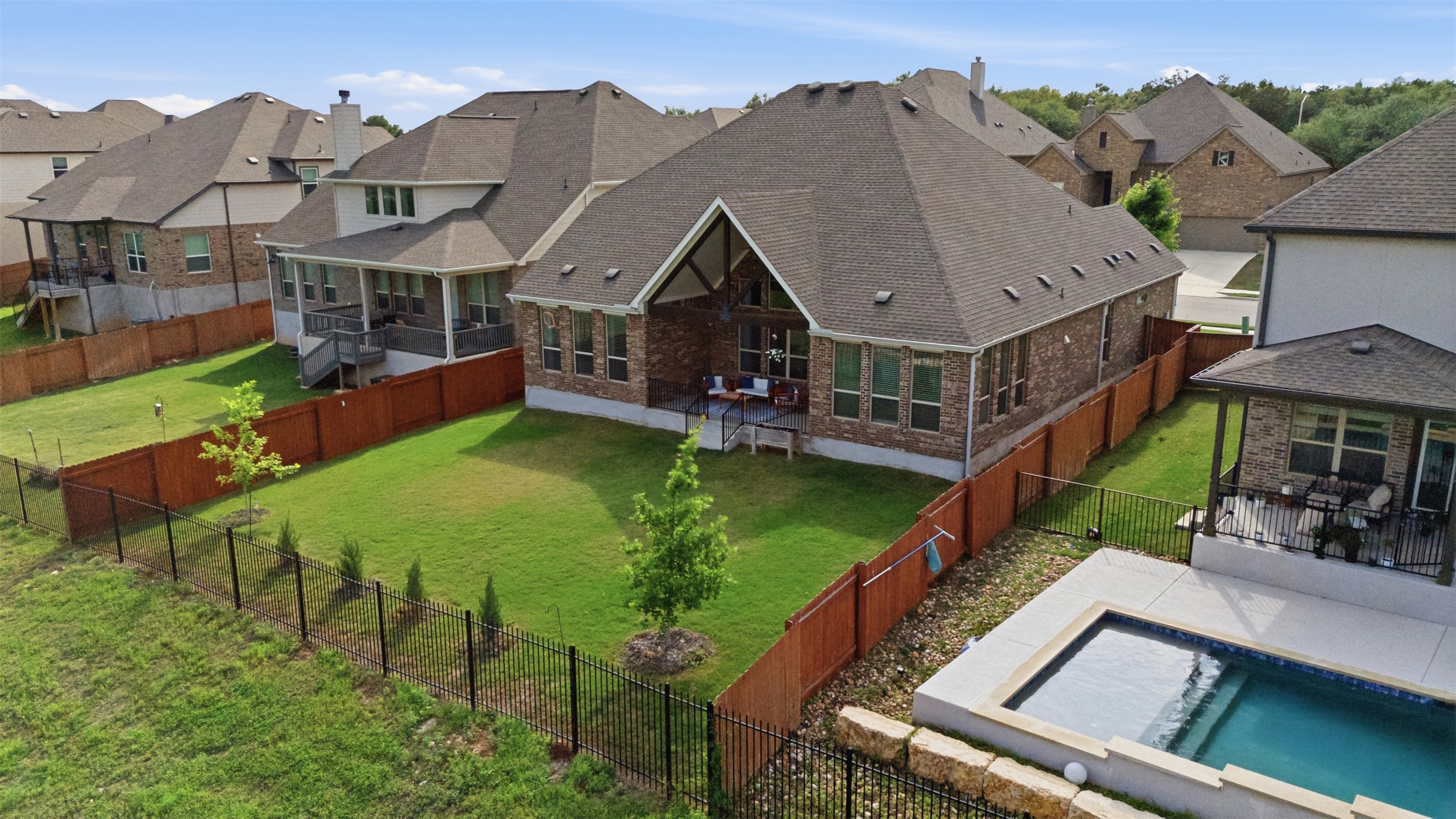 118 Bear Paw Run Georgetown, TX 78628 - Photo 31 of 35 The property features an extensive backyard with a lawn, a patio area, and a swimming pool with a hot tub