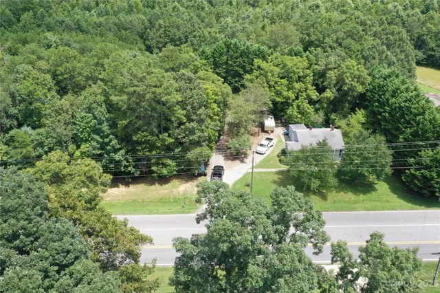 an aerial view of residential house with outdoor space and trees all around