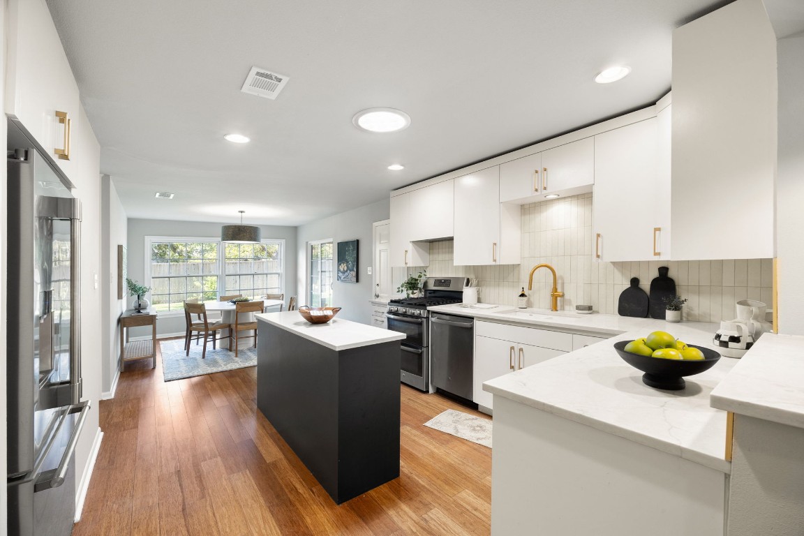 1601 Northridge Drive Austin, TX 78723 - Photo 4 of 40 a kitchen with a sink a stove cabinets and living room view