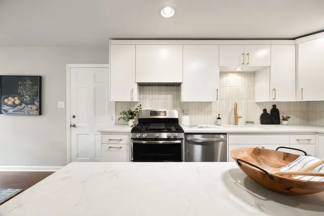 a kitchen with granite countertop a stove top oven a sink and a refrigerator