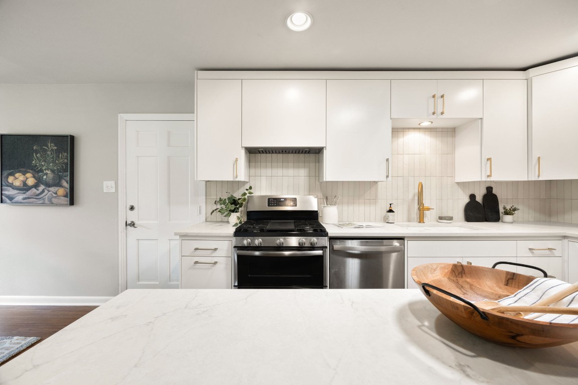 1601 Northridge Drive Austin, TX 78723 - Photo 8 of 40 a kitchen with granite countertop a stove top oven a sink and a refrigerator