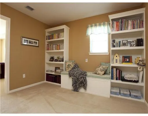 a room with a bed and a book shelf