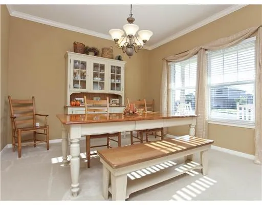 a living room with dining table and a large window